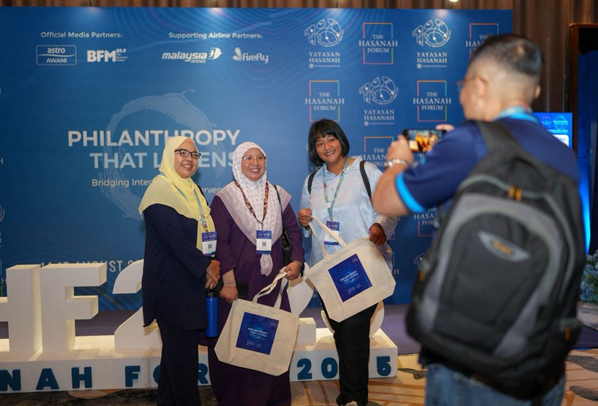 Beberapa tetamu mengambil gambar di tirai latar Forum Hasanah 2025 usai penutupan forum pada Jumaat. - Foto Yayasan Hasanah