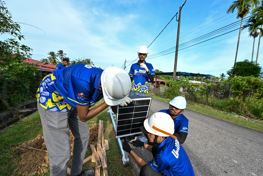 Pelajar UniMAP memasang lampu jalan solar sempena Program Cahaya Prihatin: Elektrik untuk Komuniti di Kampung Utara, Padang Besar, Perlis. - Foto UniMAP