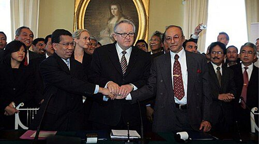 Hamid Awaluddin (Kiri) dan Malik Mahmud berjabat tangan selepas menandatangani Perjanjian Helsinki yang dimediasi oleh bekas Presiden Finland, Martti Ahtisaari.