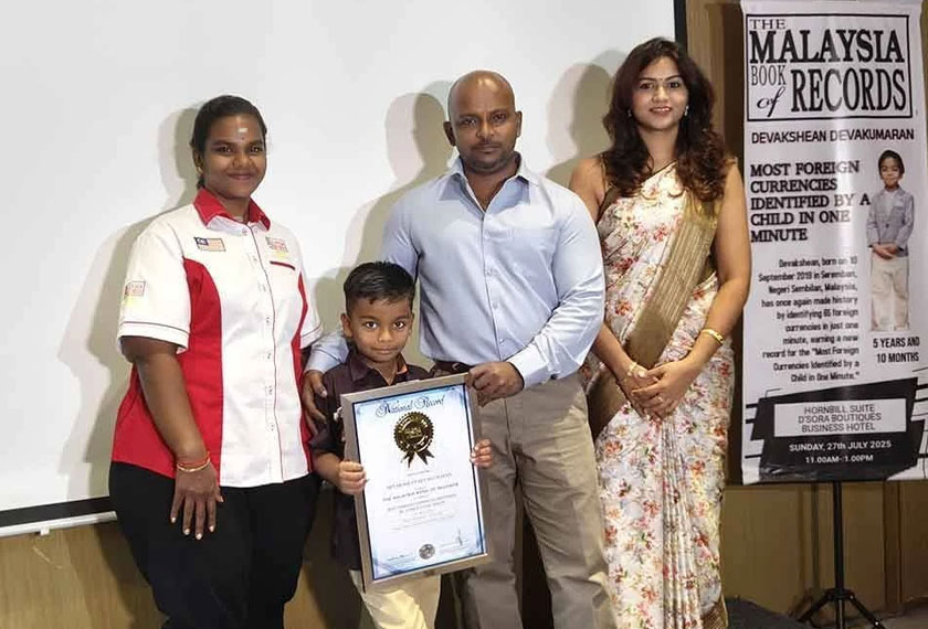 Menaga (kiri) menyampaikan sijil MBOR kepada Devakshean yang ditemani ibu bapanya. - Foto Sinar Harian