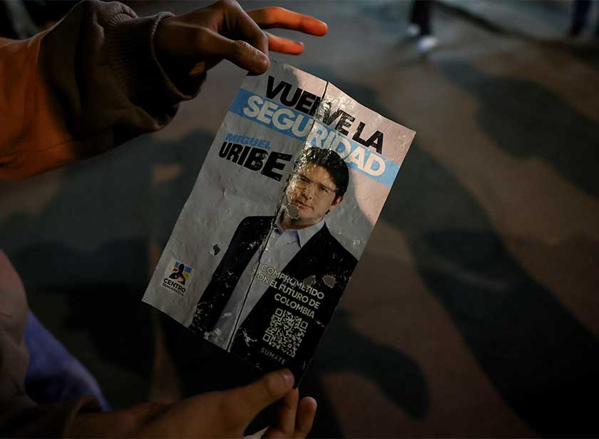 Seorang individu memegang poster kempen di kawasan di mana Senator Miguel Uribe telah ditembak pada satu acara kempen di Bogota, 7 Jun 2025. REUTERS
