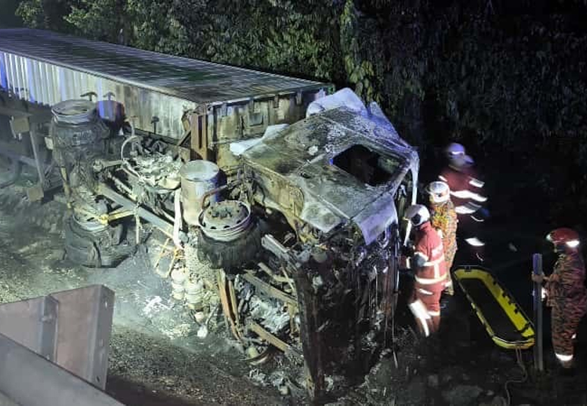 Anggota mengeluarkan mayat yang rentung dalam kemalangan di Kilometer 254 Lebuhraya Utara Selatan, arah utara, berhampiran Kuala Kangsar, awal pagi ini. - Foto JBPM Perak