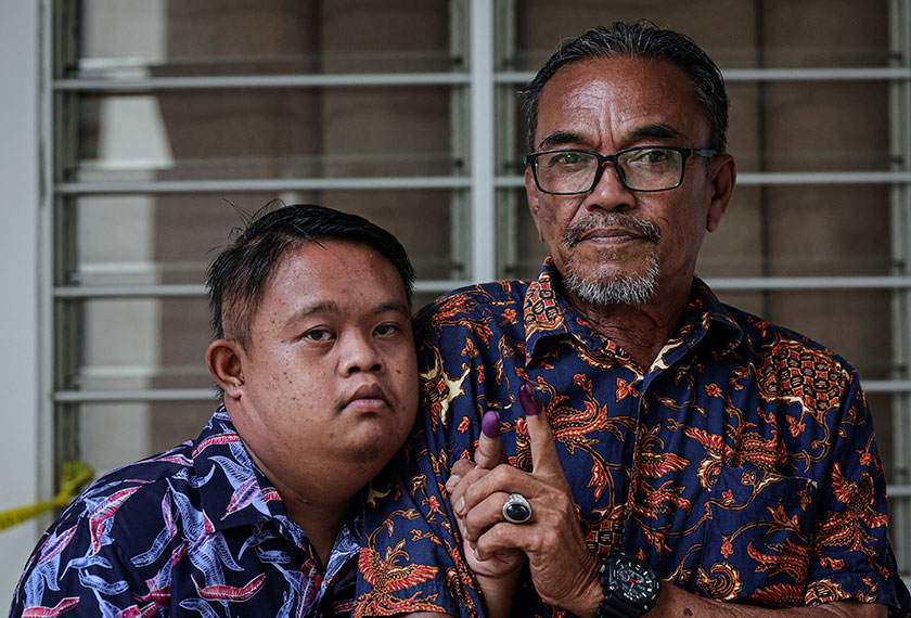 Ruzaimie, ditemani bapanya, Jamlin Saiteh, mengundi pada PRN Sabah ke-17 di Sekolah Kebangsaan Serusup, Tuaran, hari ini. --fotoBERNAMA