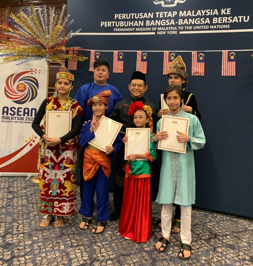 Ahmad Faisal (bersongkok) dan pemimpin Kumpulan Gemala Sitra, Akoque (belakang, kiri) bergambar bersama anak-anak kakitangan pejabat perutusan tetap.